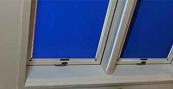 Zwei blaue Rollos in Dachgeschoss-Wohnungen