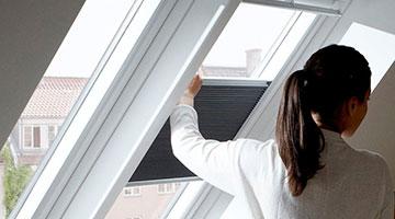 Frau bedient das Velux Faltstore schwarz 1
