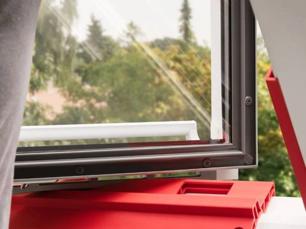 VELUX Protect-Tool ZZZ 258 am Blendrahmen eines geöffneten Dachfensters